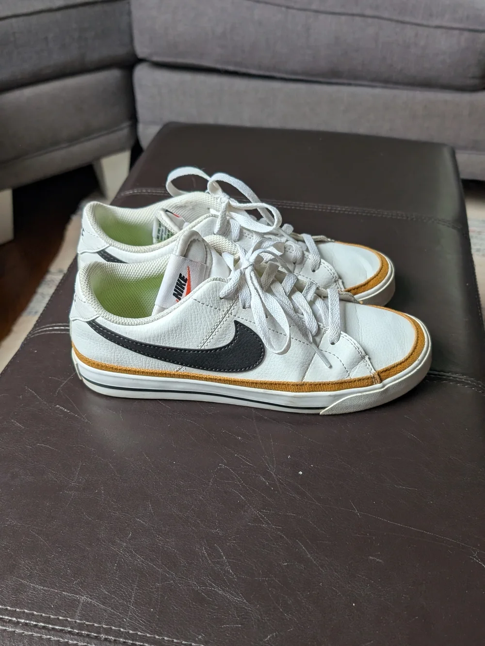 Nike Women’s White Sneakers with Black Swoosh and Gold Trim